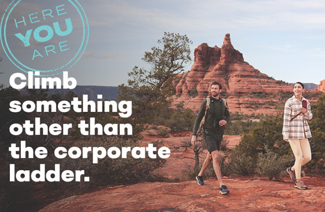 A man and a woman walking in nature in Sedona Arizona. They are smiling and looking off camera.